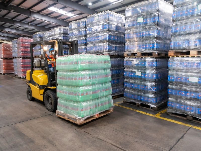 Forklift moving shrink-wrapped pallets