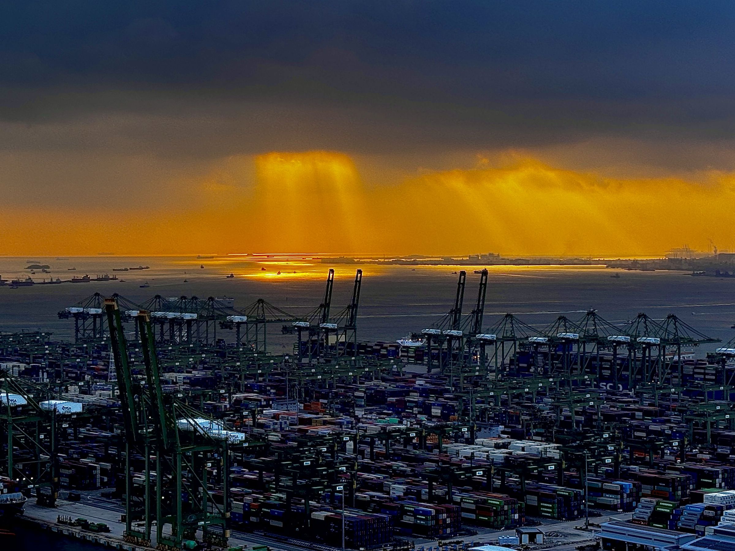 Sunset over a container terminal with cranes and stacked containers